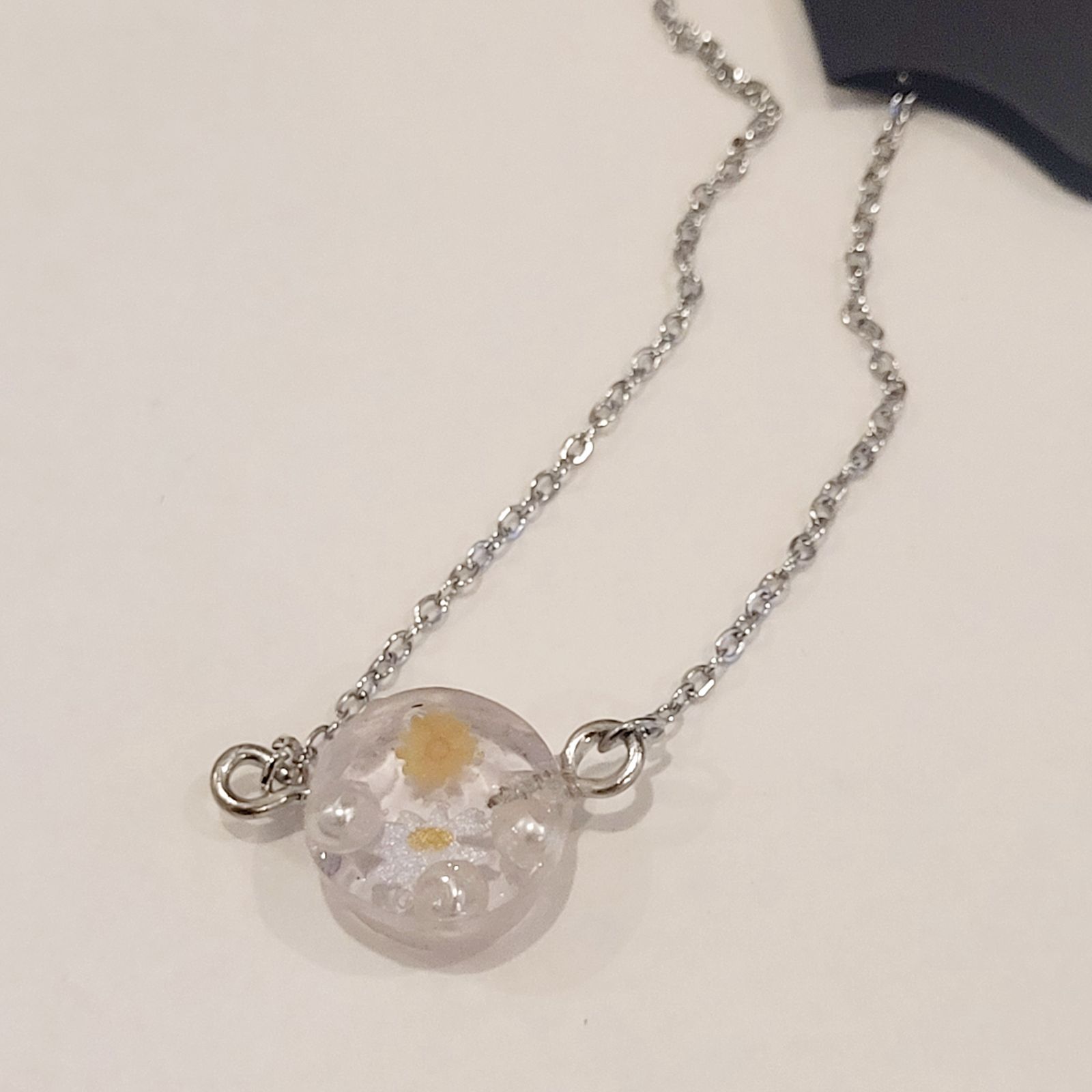 a necklace with a glass ball on a chain