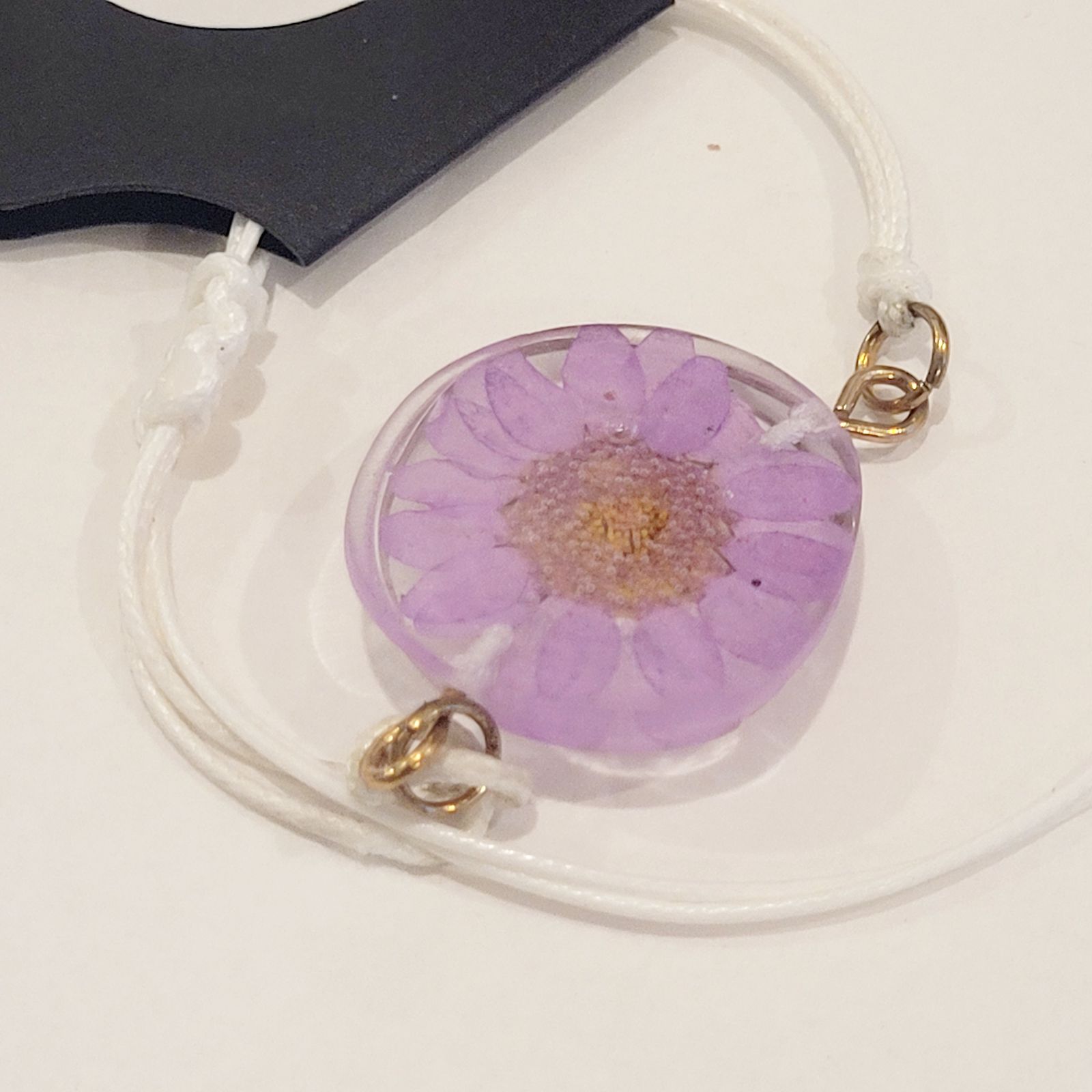 a purple flower is attached to a cord