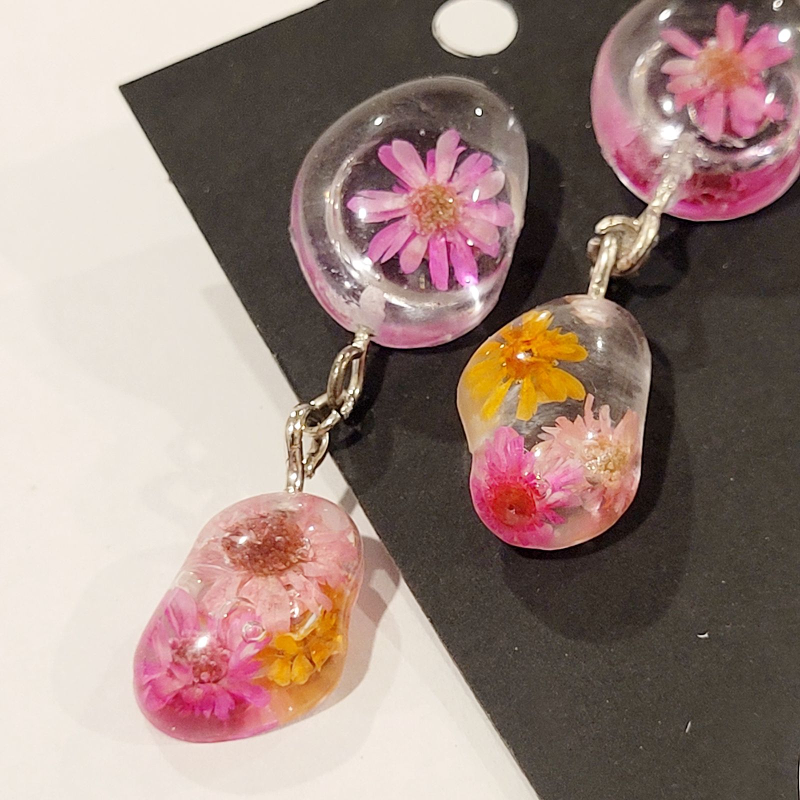 a pair of earrings with flowers in them