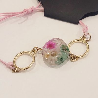 a necklace with a flower on it on a table