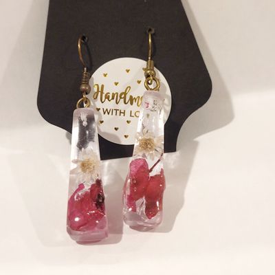 a pair of earrings with a heart inside of it