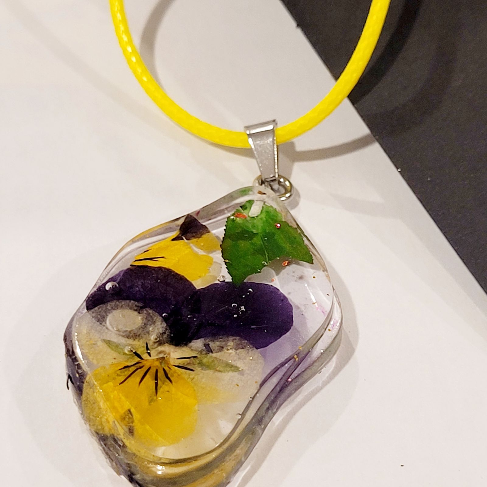 a glass pendant with a yellow cord around it