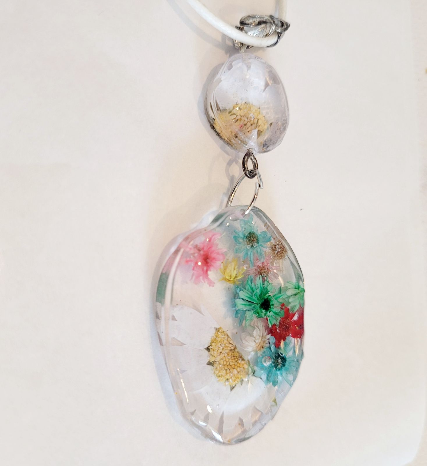 a glass pendant with flowers on a white background
