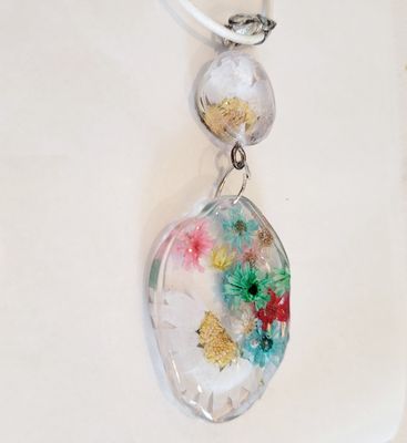 a glass pendant with flowers on a white background
