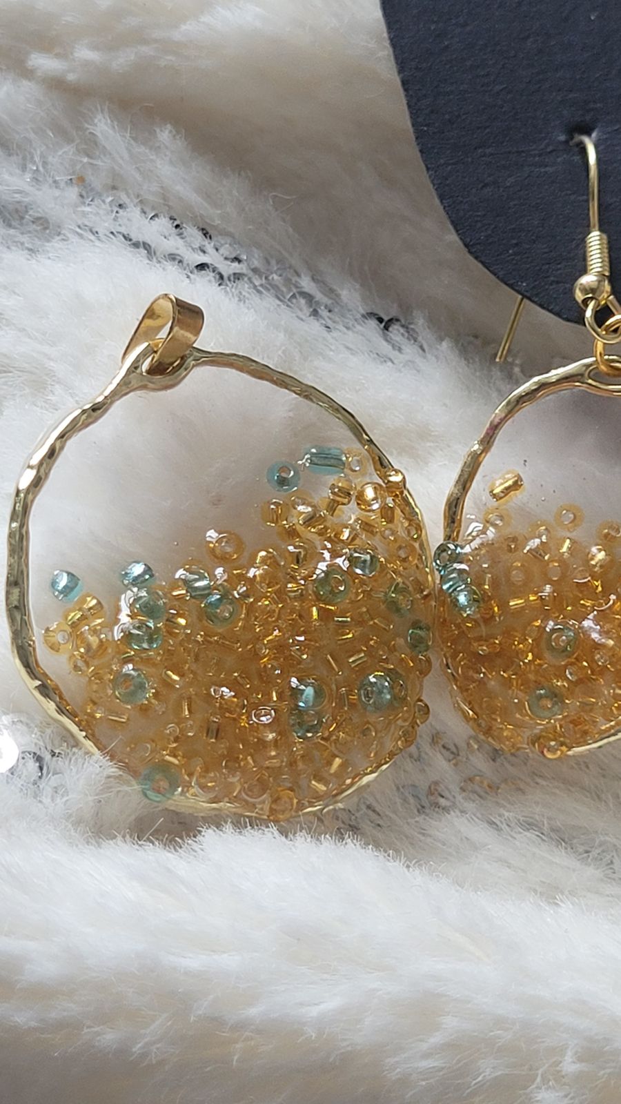 a pair of gold hoop earrings with green beads