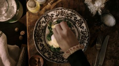 a person's hand on a plate with food on it