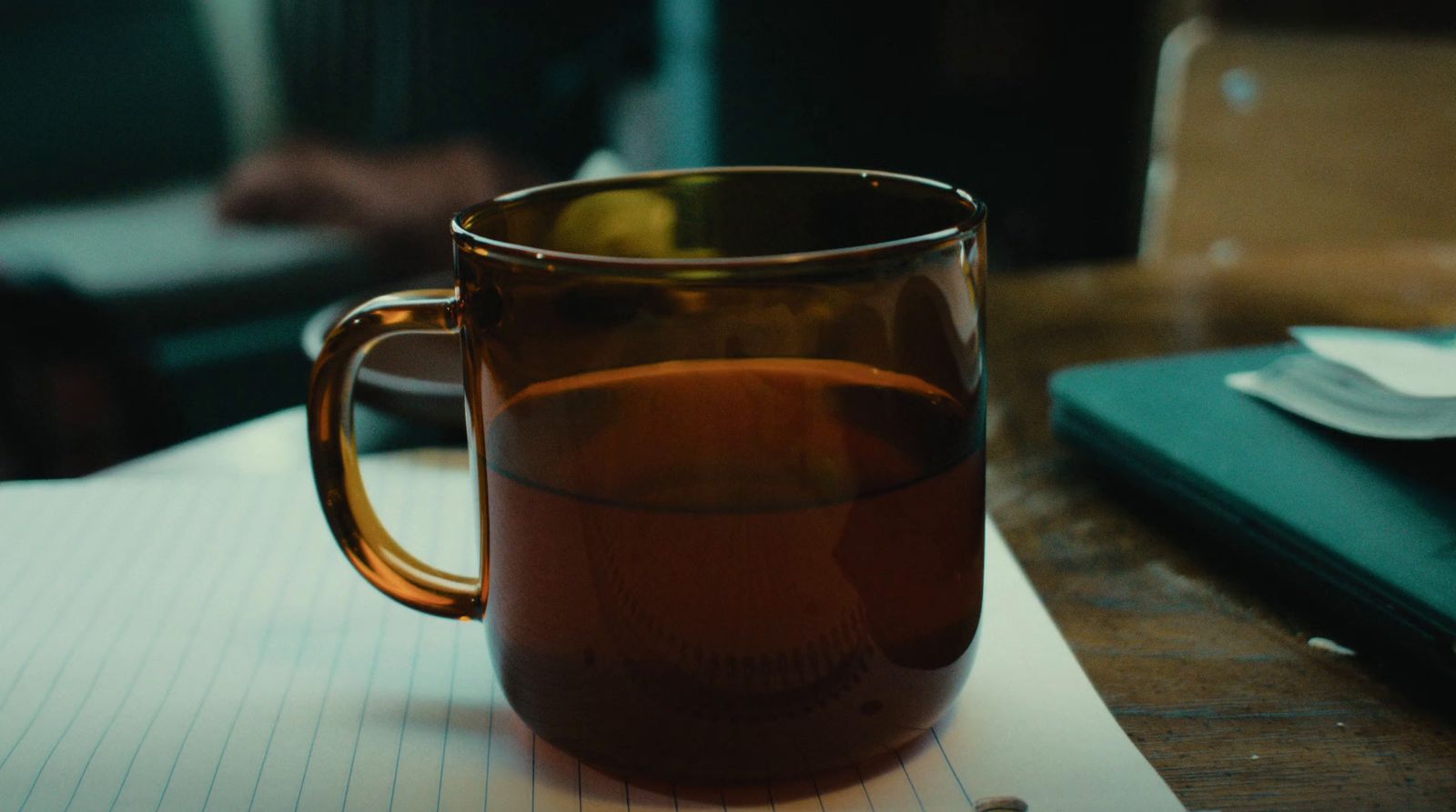 a cup of tea sitting on top of a notebook