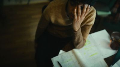 a person sitting at a table with papers and a cell phone