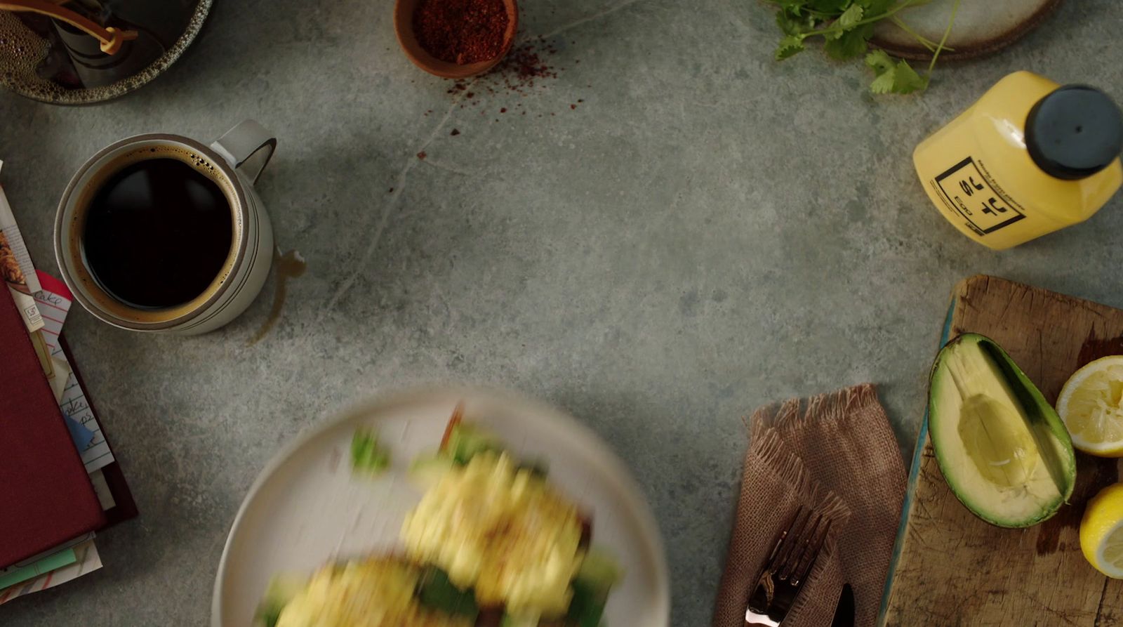 a plate of food on a table next to a cup of coffee