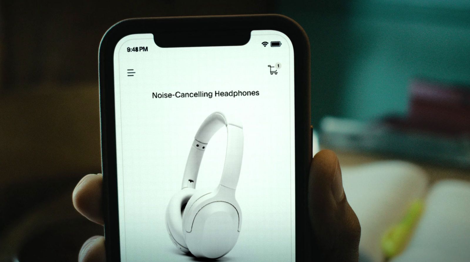 a person holding up a cell phone with headphones on it