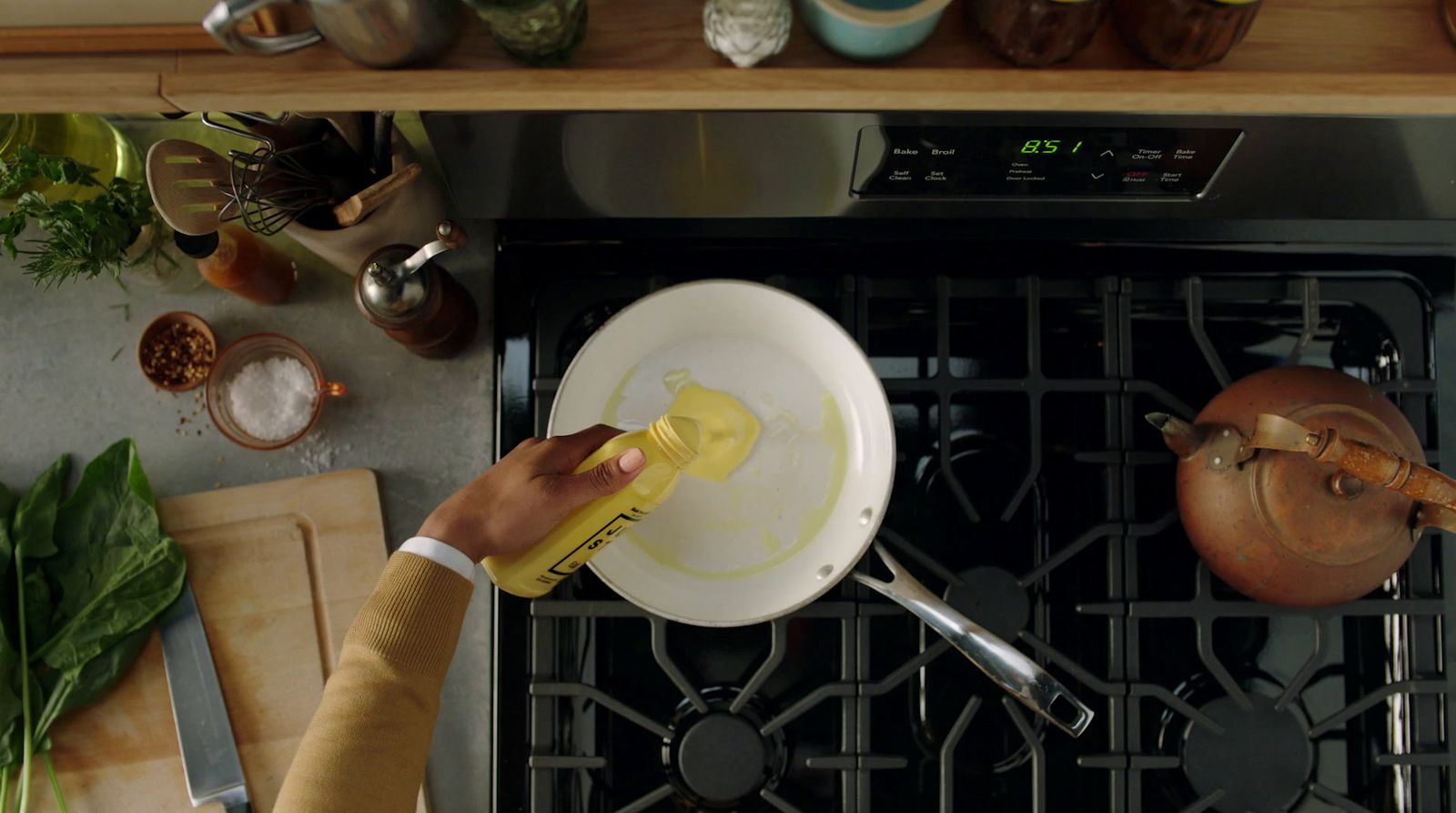 a person cleaning a stove with a sponge