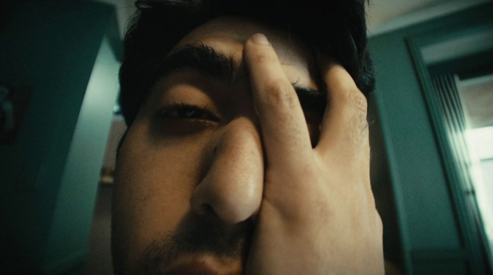 a man covering his face with his hands