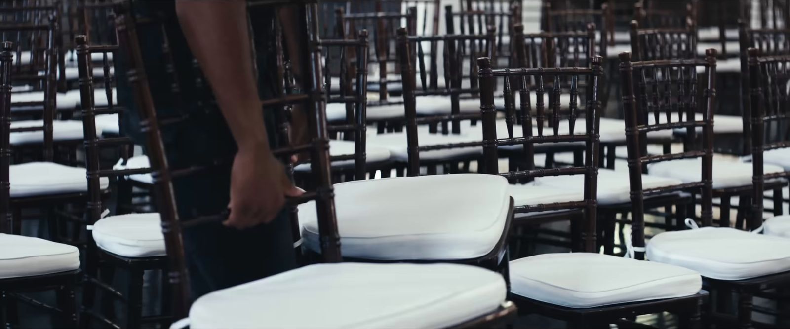 a person standing next to a bunch of chairs