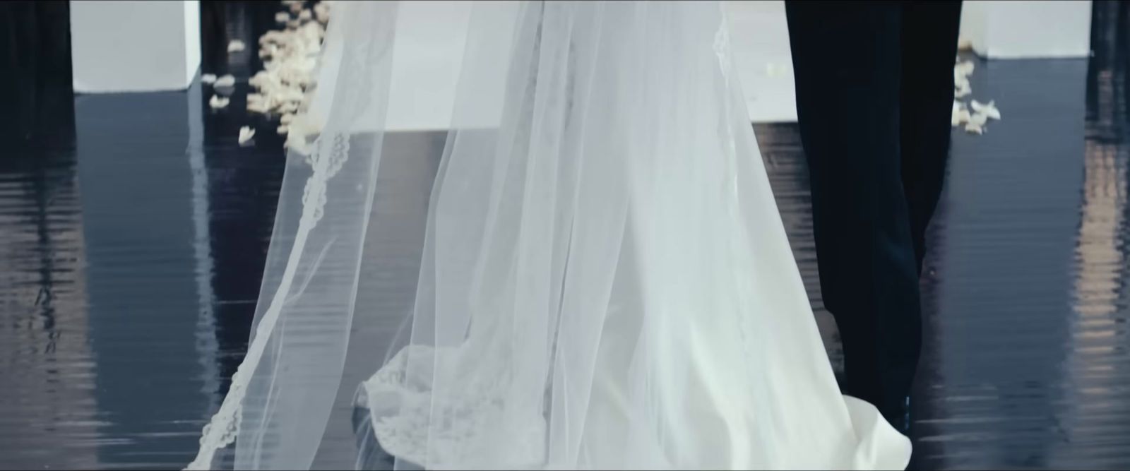 a bride and groom are standing in the rain