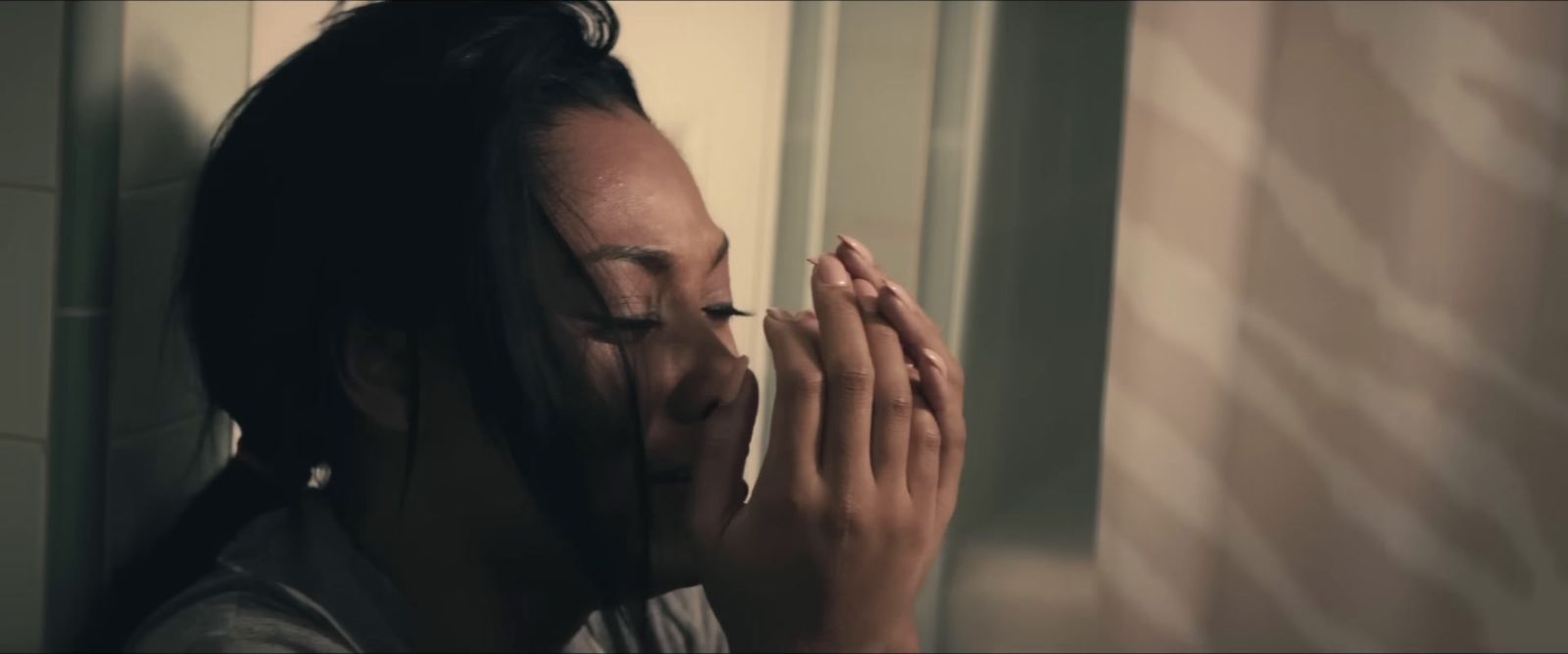 a woman with dreadlocks holding her hands together