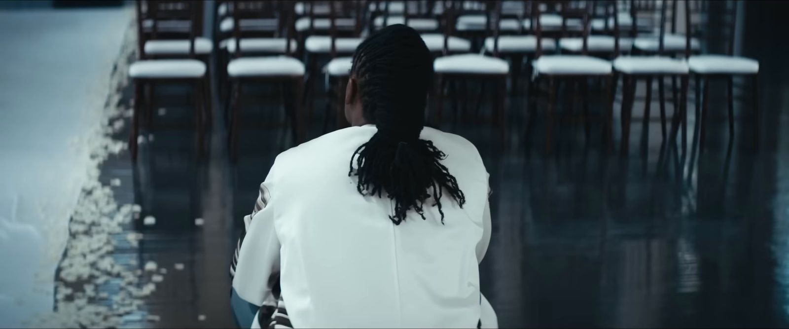 a woman standing in front of a row of chairs