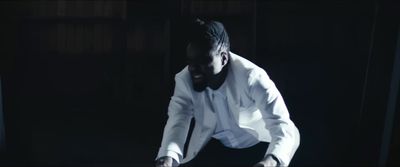 a man in a white shirt and tie in a dark room