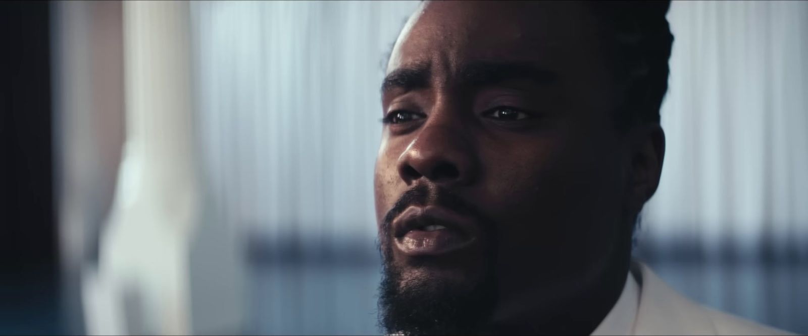 a close up of a person wearing a suit and tie