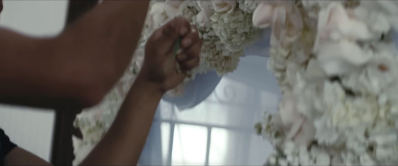 a man is putting flowers on a wall