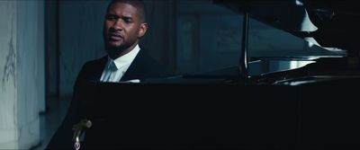 a man in a suit sitting at a piano