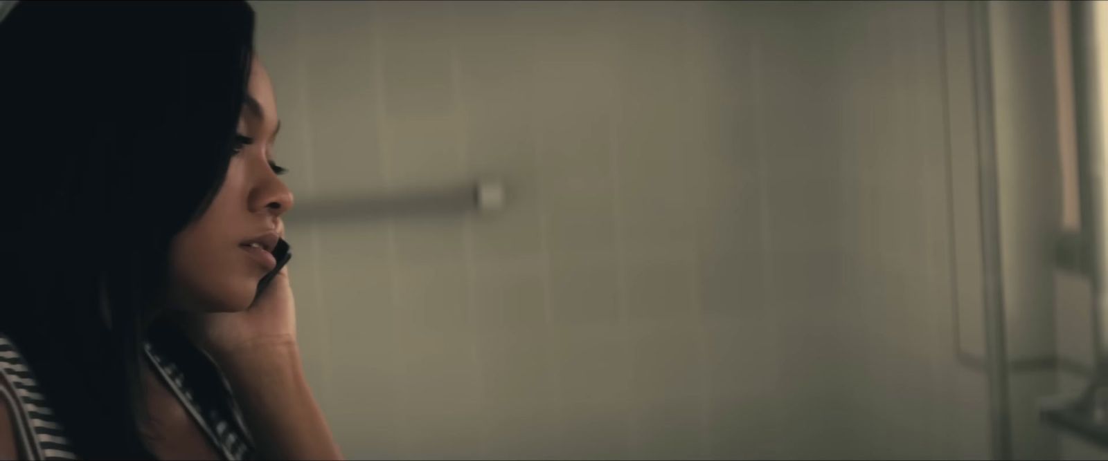 a woman talking on a cell phone in a bathroom