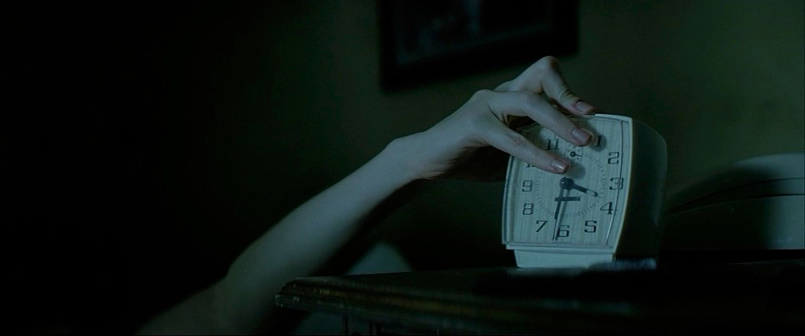 a person holding a clock in the dark