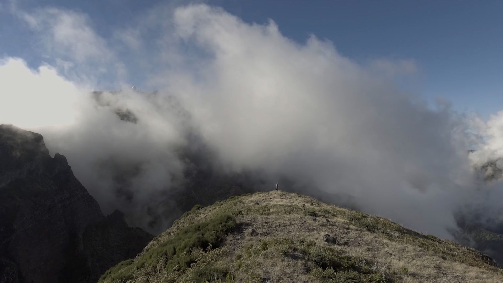 a mountain covered in clouds on a sunny day