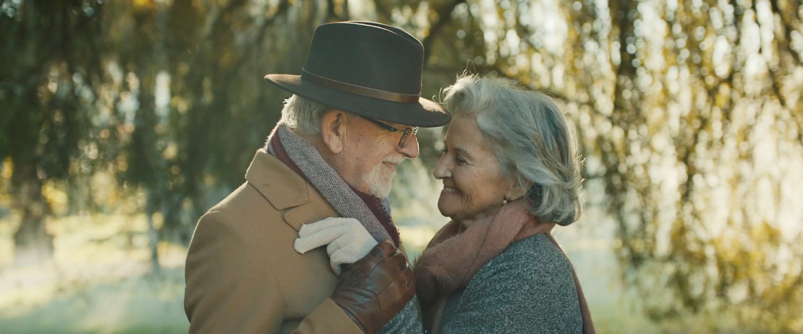 a man and woman standing next to each other under a tree