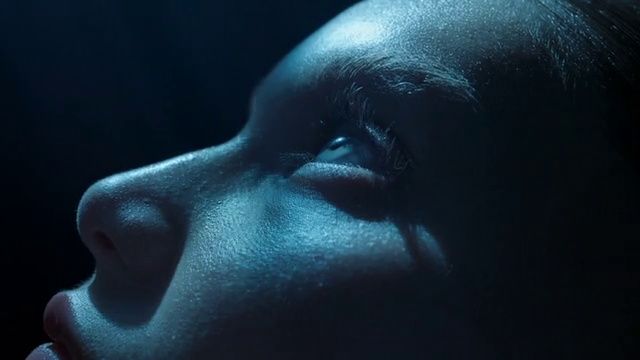 a close up of a woman's face with a dark background