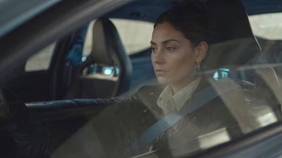 a woman sitting in a car looking out the window