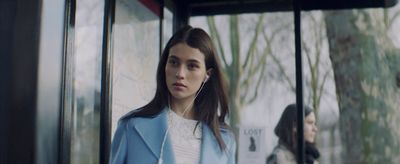 a woman standing in front of a bus