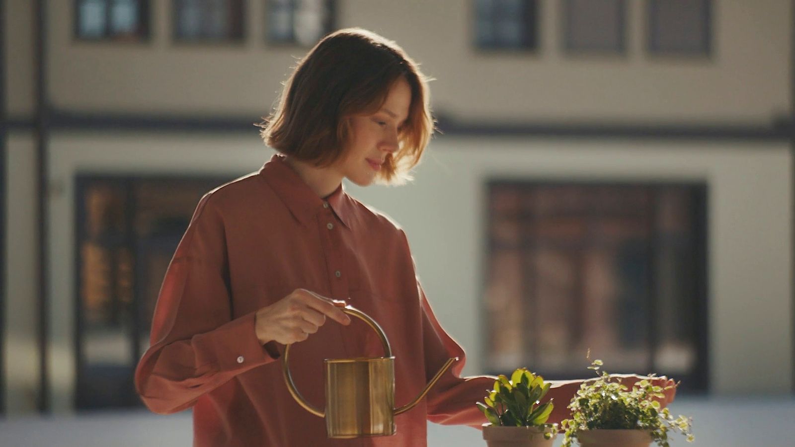 a woman watering flowers with a watering can