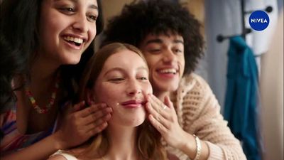 a group of women are smiling and touching each other's cheeks