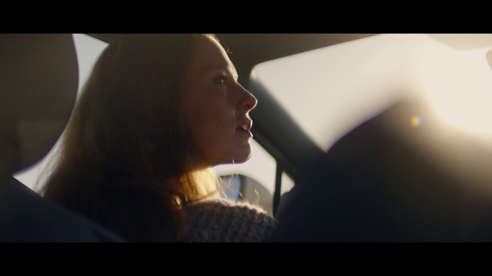 a woman sitting in a car looking out the window