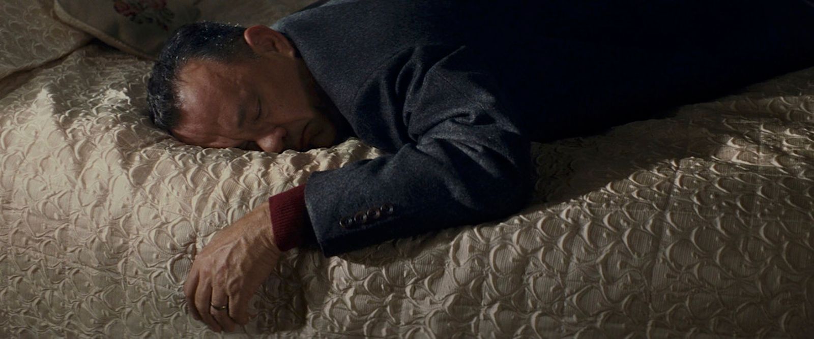 a man laying on a bed with his head on the pillow