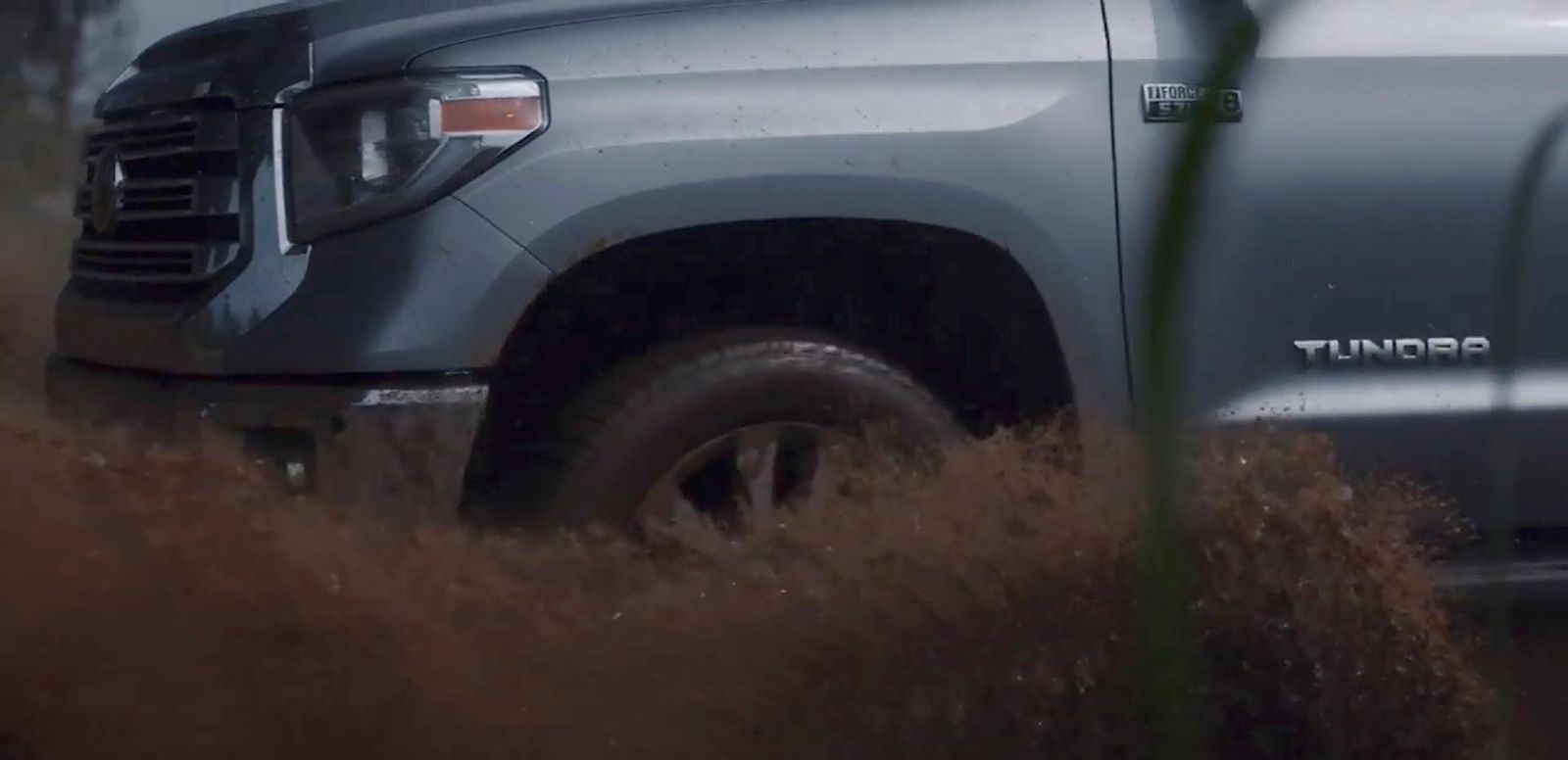 a silver truck is parked in a field