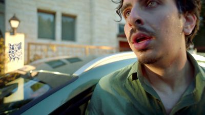 a man standing in front of a car with a surprised look on his face