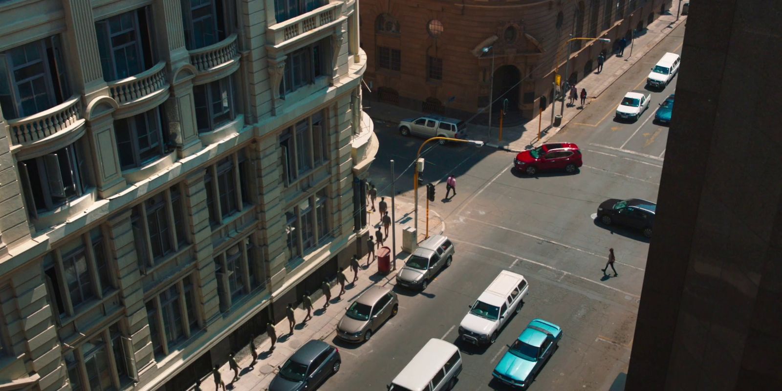 a city street filled with lots of traffic next to tall buildings