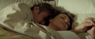 a man and a woman laying in bed together