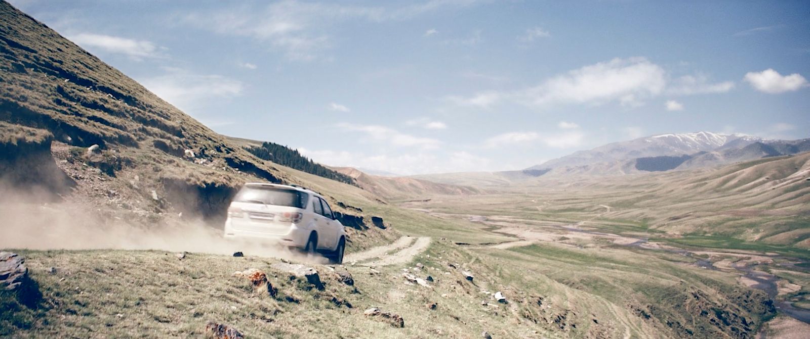 a white car driving down a dirt road