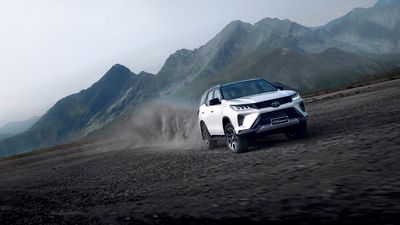 a white suv driving down a dirt road