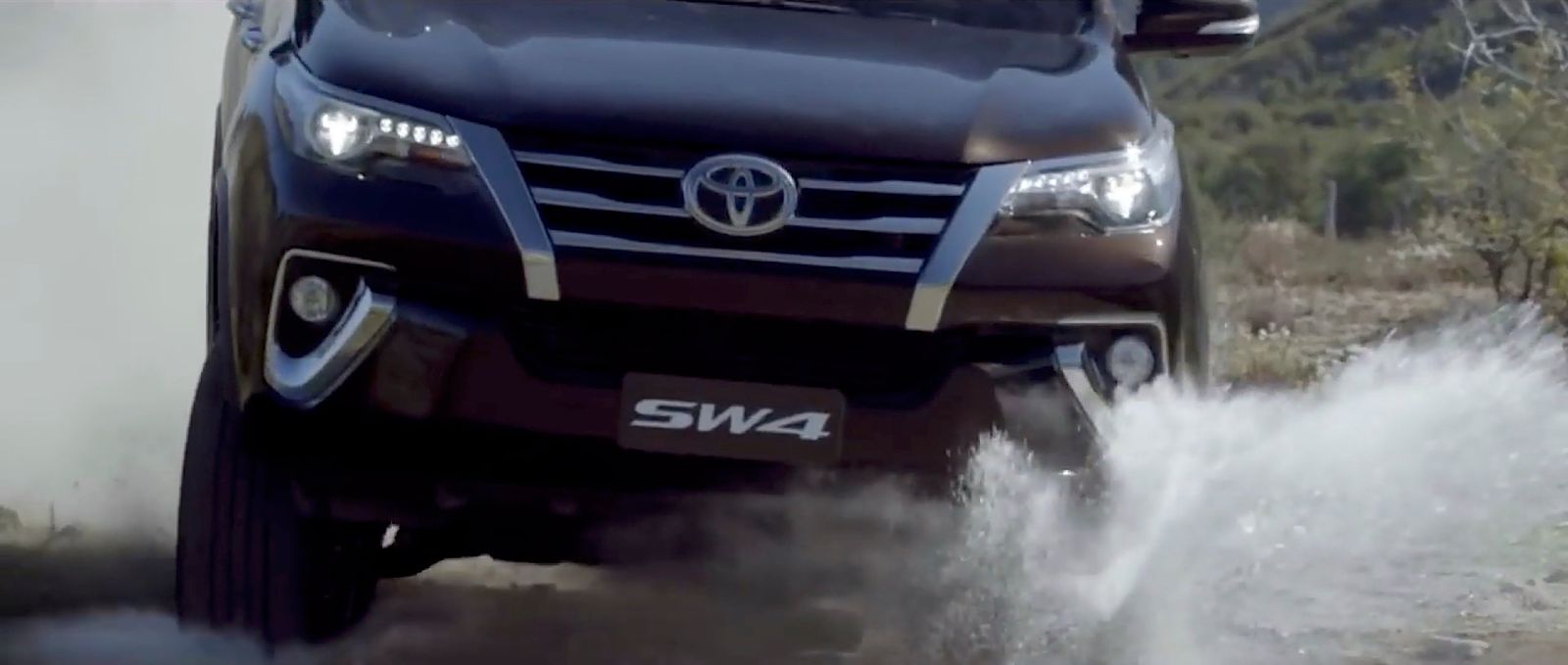 a black truck driving down a dirt road