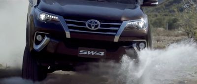 a black truck driving down a dirt road