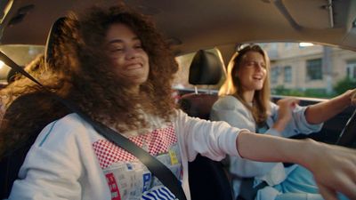 a couple of women sitting in a car next to each other