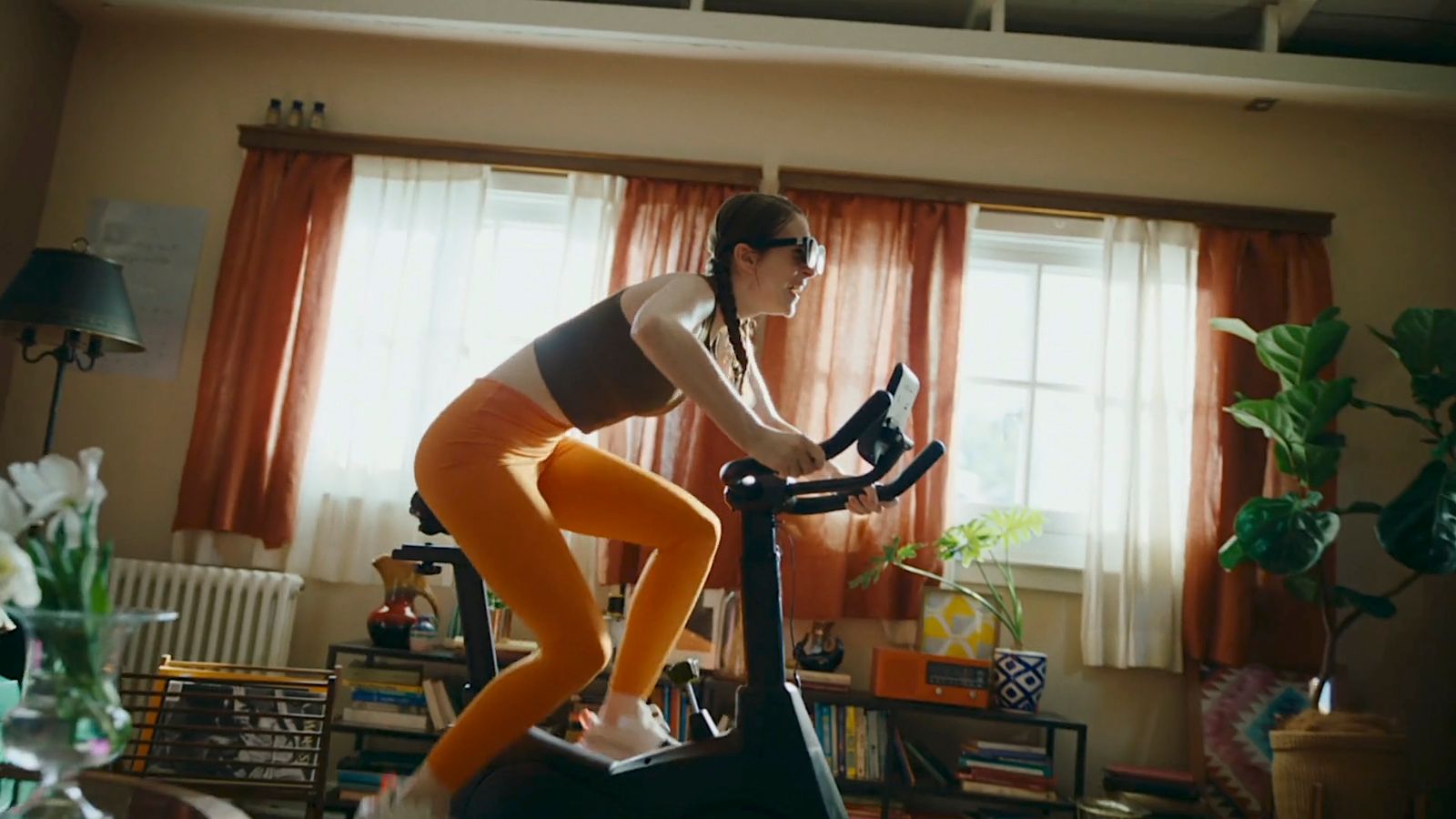 a woman riding a stationary bike in a living room