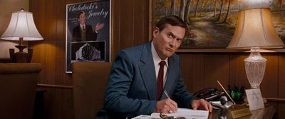 a man in a suit sitting at a desk