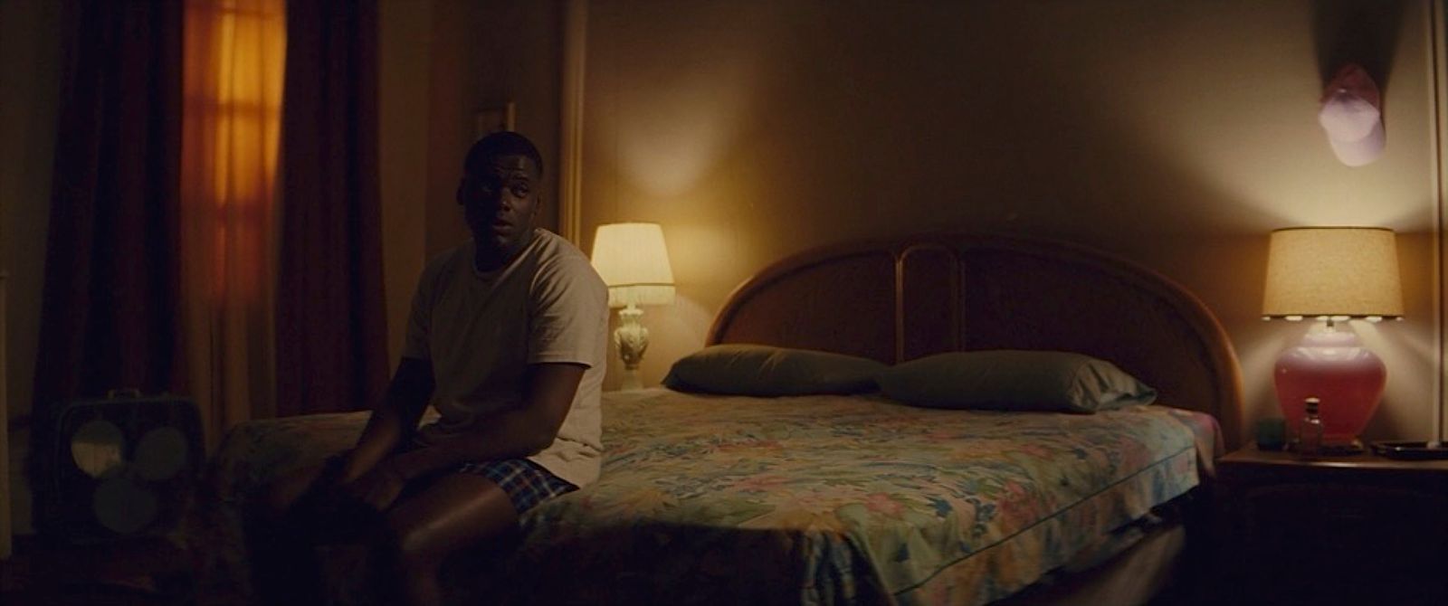 a man sitting on a bed in a dimly lit room