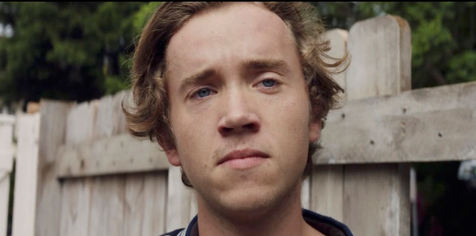 a close up of a person near a fence