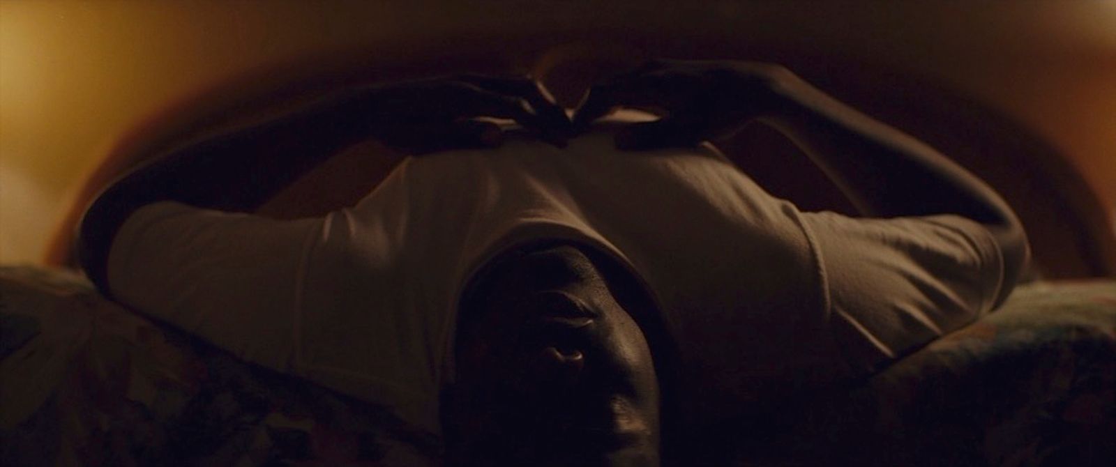 a person laying on a bed in a dark room