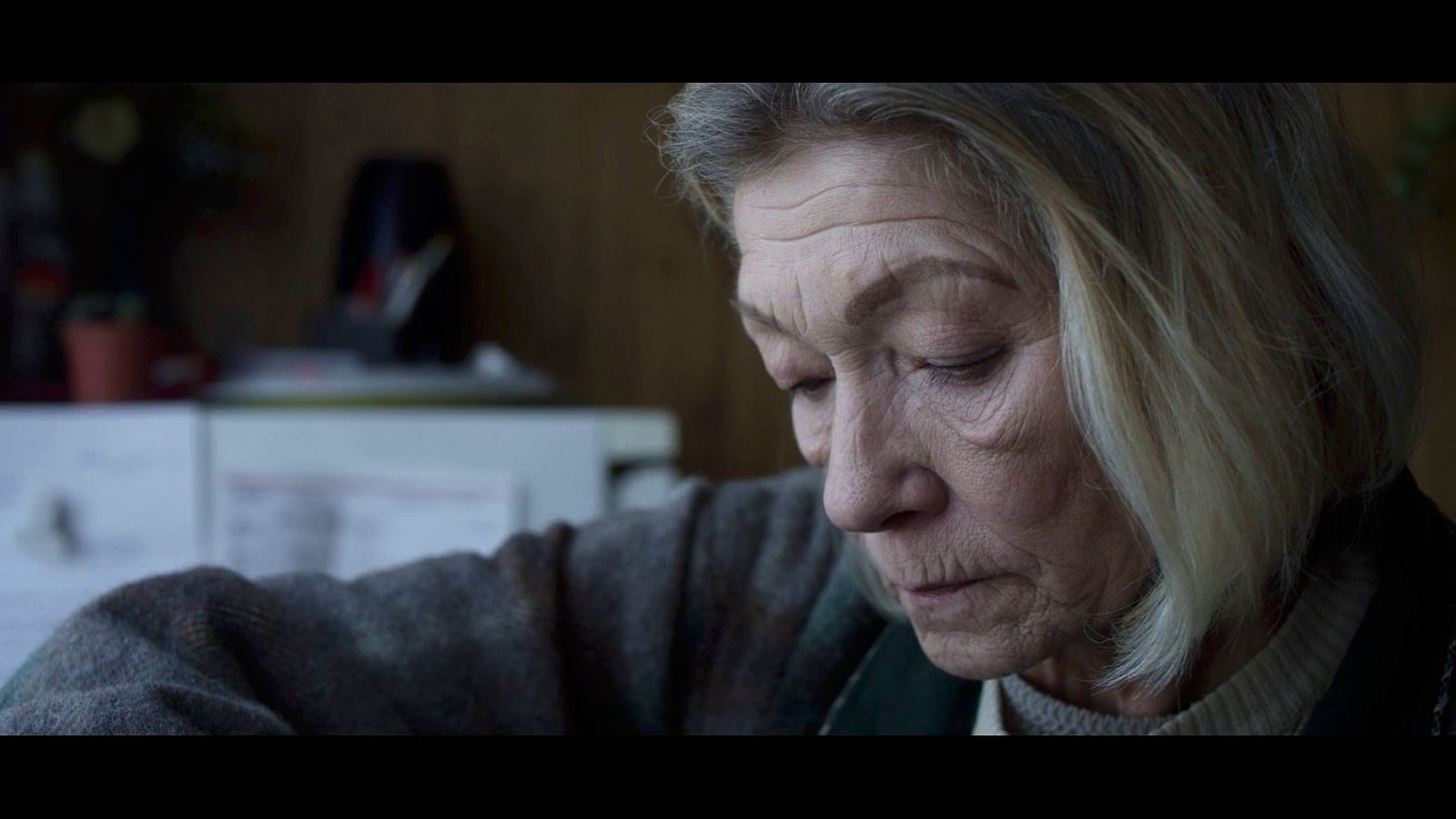 an older woman looking down at a piece of paper